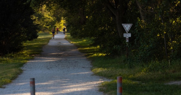 : Runners and a cyclist share the MoPac East Trail near Walton, Nebraska, on Sept. 10. (Liz McCue/University Communication and Marketing)